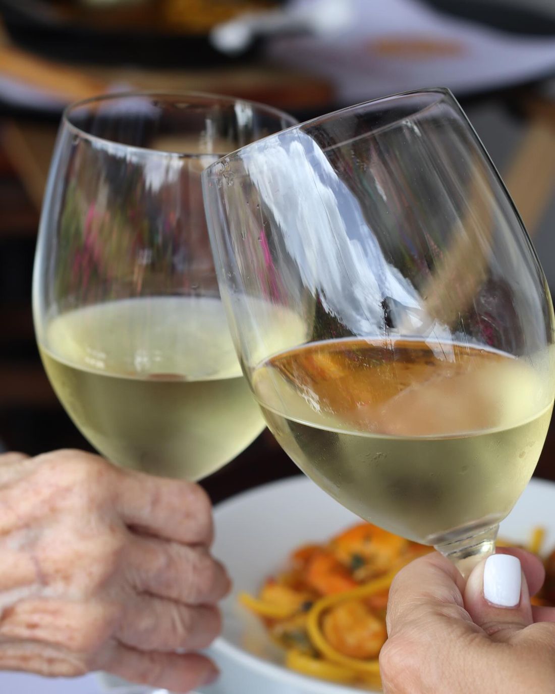 Brindis con vino blanco en la mesa