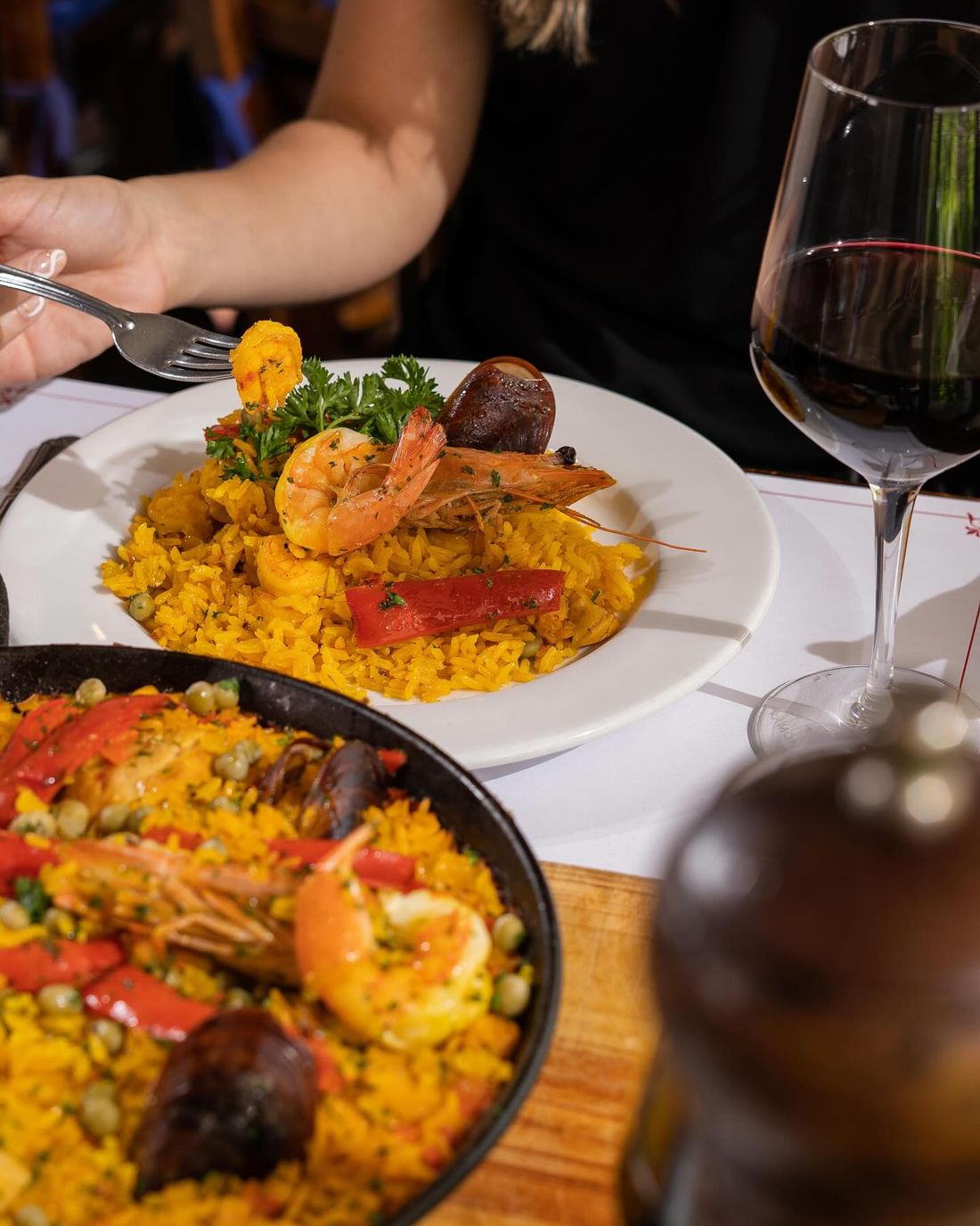 Paella y vino tinto servidos en la mesa
