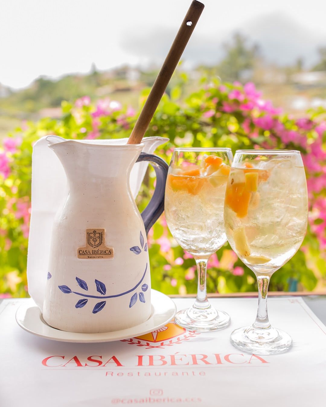 Jarra de sangría blanca con copas en la terraza