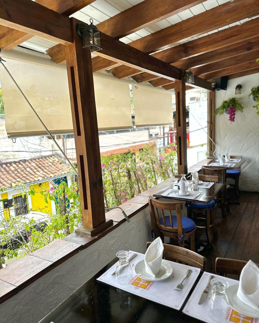 Terraza techada con mesas puestas y vista al pueblo